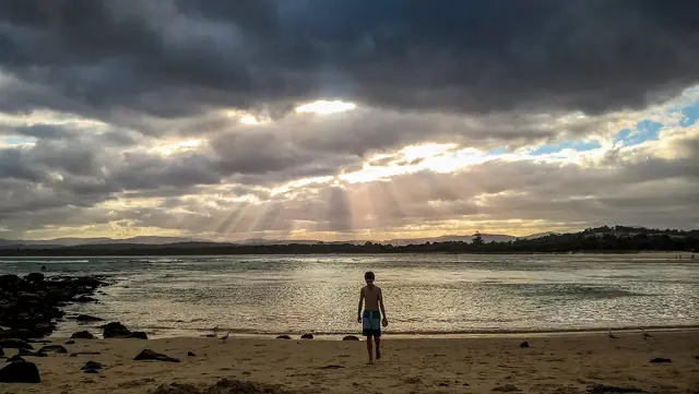 Sun breaking through clouds over Merimbula Bar Beach